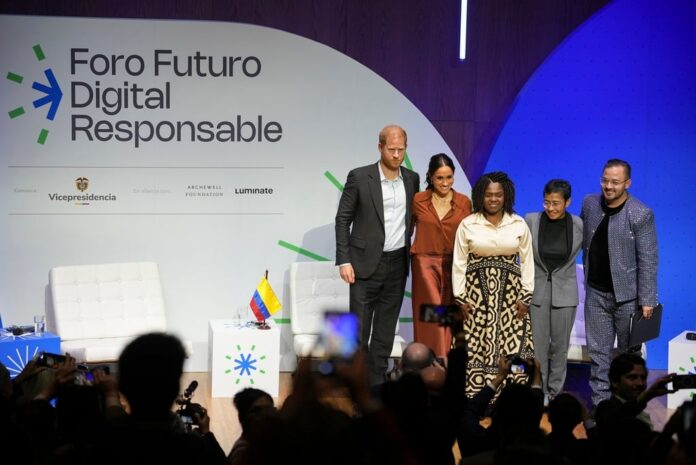 Prince Harry and Meghan pose for photos alongside Colombian Vice President Francia Marquez, center, after speaking at a forum on digital responsibility at EAN University in Bogota, Colombia, Thursday, Aug. 15, 2024. (AP Photo/Ivan Valencia).