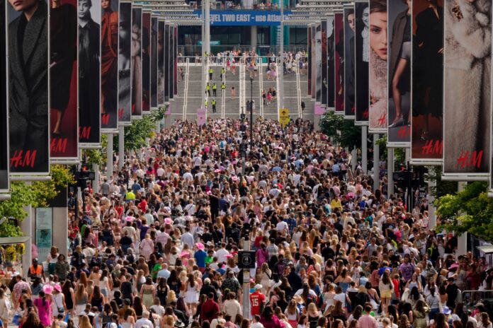 Fans of singer Taylor Swift, called Swifties, arrive at Wembley Stadium in London, Thursday, Aug. 15, 2024 for the first of five concerts of Taylor Swift's Eras Tour.(AP Photo/Alastair Grant).