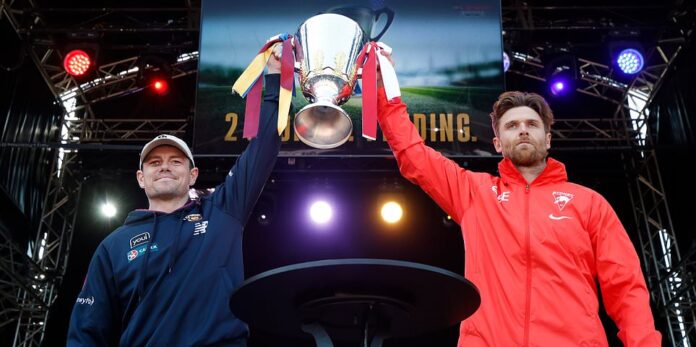 MELBOURNE, AUSTRALIA – SEPTEMBER 27: Lachie Neale of the Lions is the last to touch the cup as Dane Rampe of the Swans looks on during the 2024 AFL Grand Final Parade on September 27, 2024 in Melbourne, Australia. (Photo by Michael Willson/AFL Photos via Getty Images)