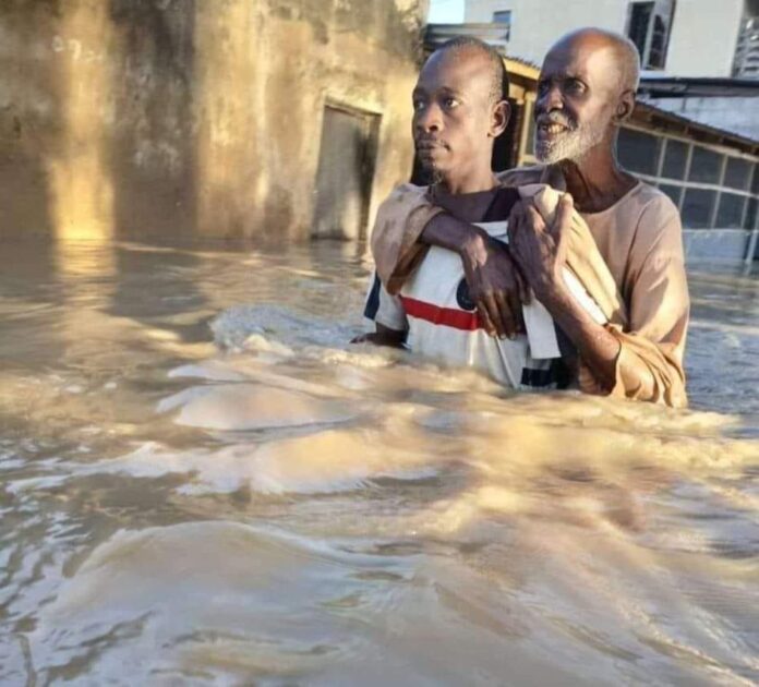 HOTO MAI BAYA: Dan ya dauki mahaifinsa a bayansa yayin da yake taimaka masa a lokacin ambaliyar ruwa a Maiduguri