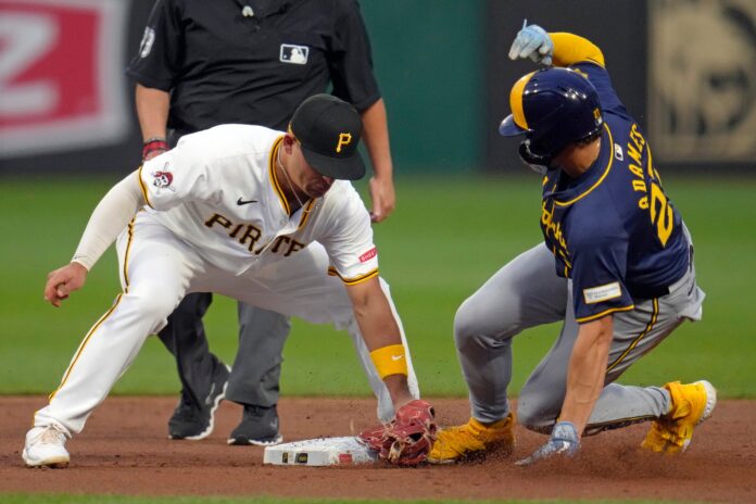 Milwaukee Brewers' Willy Adames, right, slides safely into second with a stolen base ahead of the tag attempt by Pittsburgh Pirates second baseman Nick Yorke, left, during the second inning of a baseball game in Pittsburgh, Tuesday, Sept. 24, 2024. (AP Photo/Gene J. Puskar).